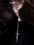 A Priest Holds a Crucifix Photographic Print