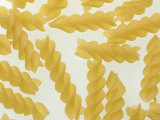 Many Uncooked Rotini Pasta Noodles on a White Surface Photographic Print