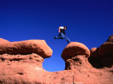 A Man Jumps onto a Hoo-Doo Formation in Goblin Valley, Goblin Valley State Park, Utah, USA Photographic Print by Cheyenne Rouse