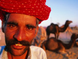 Rajput Camel Driver at Pushkar Camel Fair, Looking at Camera, Pushkar, India Fotografisk tryk af Paul Beinssen Rajput Camel Driver at Pushkar Camel Fair, Looking at Camera, Pushkar, India Fotografisk tryk af Paul Beinssen