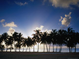 Sun Setting Behind Palm Tree Lined Shore of West Coast, Cook Islands Photographic Print by Manfred Gottschalk