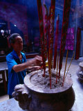 Man Making Incense Offerings in Temple, Vietnam Photographic Print by Mason Florence