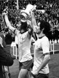 Charlie George and Skipper Frank Mclintock Celebrate in Front of Fans After Defeating Liverpool Lámina fotográfica Charlie George and Skipper Frank Mclintock Celebrate in Front of Fans After Defeating Liverpool Lámina fotográfica