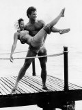 Actor Steve Reeves on a Pier by the Sea, Carrying Woman in a Bikini and Headscarf Lámina fotográfica