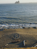 Rock Art on Beach with Arch Rock on Horizon Photographie par Skip Brown