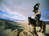 Hunter on Horseback Atop a Hill Holding a Golden Eagle in Mongolia Photographie par David Edwards