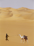Tuareg Guide Leads a Camel Across the Awbari Sand Sea Photographie par Bobby Model