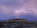 Lightning Strikes Above a Butte in Adobe Town in Wyoming's Red Desert Photographie par Joel Sartore