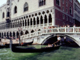 Gondolier Maneuvers His Boat Under a Bridge Crossing a Canal Lámina fotográfica por Rex Stucky