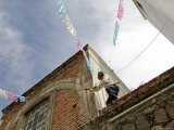 Man Preparing for Festival by Putting Up Bunting Photographie par Dan Gair