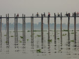 People Ride their Bicycles Along U Bein's Bridge That Runs Down the Taungthaman Lake Photographic Print by David Greedy