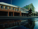 Motorcyclist Riding Past Shops on Front Street Photographic Print by Nicholas Pavloff