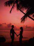 Couple Enjoying a Romantic Sunset on the Beach Photographie par Bill Bachmann