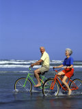 Retired Couple Riding Bikes at the Beach Photographie par Bill Bachmann