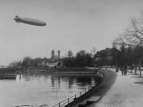 The Hindenburg Airship of Zeppelin Design Flying over City Where it was Fabricated Impressão fotográfica