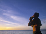 Man Blowing Inro a Seashell, Samoa Photographie par Neil Farrin