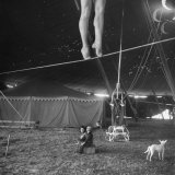 Two Small Children Watching Circus Performer Practicing on Tightrope, Her Legs Only Visible Fotografisk tryk af Nina Leen Two Small Children Watching Circus Performer Practicing on Tightrope, Her Legs Only Visible Fotografisk tryk af Nina Leen