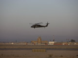 UH-60 Blackhawk Helicopter Flies Past the Tower on Camp Speicher Lámina fotográfica por Stocktrek Images