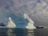 National Geographic Endeavour Framed in a Beautiful Iceberg Arch, Antarctic Peninsula, Antarctica Photographic Print by Paul Nicklen