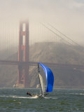 International 14 Skiff Sails under the Golden Gate Bridge, San Francisco Bay, California Photographie par Skip Brown