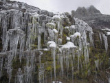 Icicles hanging from rock face at Logan Pass Photographic Print by Michael Melford