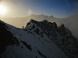 Climber on a steep ridge of Nanga Parbat with the sun guiding his way Photographic Print by Tommy Heinrich