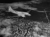 Plane Flying over a City from a Story Concerning United Airlines Lámina fotográfica por Carl Mydans