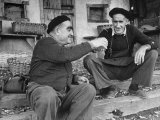 Two Older Basque Men Sitting on a Porch Toasting, as They Prepare to Drink Together Lámina fotográfica por Dmitri Kessel Two Older Basque Men Sitting on a Porch Toasting, as They Prepare to Drink Together Lámina fotográfica por Dmitri Kessel