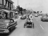 Riding in Reproduction of 1901 Oldsmobile in Beach Front Street Lámina fotográfica