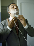 Director Federico Fellini with Powder on His Face as He Shaves with an Electric Shaver Lámina fotográfica por Carlo Bavagnoli