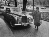Chief of Protocol Wiley T. Buchanan Jr. Walking by a Bentley Lámina fotográfica por Ed Clark Chief of Protocol Wiley T. Buchanan Jr. Walking by a Bentley Lámina fotográfica por Ed Clark
