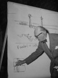 Swiss Architect Le Corbusier Standing on Stage with Notes in His Hand and Drawing on Sketch Pad Lámina fotográfica Swiss Architect Le Corbusier Standing on Stage with Notes in His Hand and Drawing on Sketch Pad Lámina fotográfica