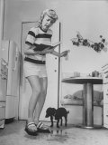 Woman Scrubbing Kitchen Floor with Brushes Attached to Her Feet Lámina fotográfica por Allan Grant Woman Scrubbing Kitchen Floor with Brushes Attached to Her Feet Lámina fotográfica por Allan Grant