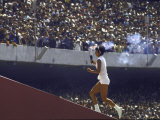 The Torch Being Carried Up the Steps in the Olympic Stadium at the Summer Olympics Lámina fotográfica por John Dominis