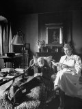 Art Critic Bernard Berenson Sitting Back in Chair While Secretary Nicky Mariano Reads to Him Lámina fotográfica por Dmitri Kessel