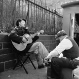 Folk Singer Woody Guthrie Palying His Guitar While Getting a Shoeshine Lámina fotográfica de primera calidad