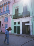 Man with Guitar Walking Past Coloured Buildings in Central Havana, Cuba, West Indies Photographie par McCoy Aaron