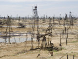 Closely Spaced Drilling Towers and Nodding Donkey Beam Pumps, Ramana Oilfield, Baku, Azerbaijan Photographic Print by Waltham Tony