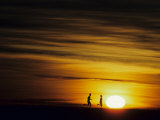 Couple Running at Sunset Photographic Print