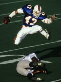 Football Running Back Flys over the Defense Fotografie-Druck