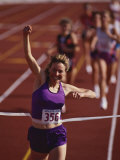 Female Runner Victorious at the Finish Line in a Track Race Photographie