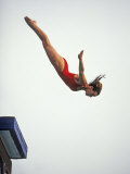 Woman Diver Flying Through the Air, California, USA Photographic Print by Paul Sutton