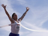 Male Runner Victorious at the Finish Line in a Track Race Lámina fotográfica