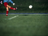 Male Soccer Player Kicking a Soccer Ball Photographic Print by Steven Sutton