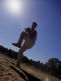Silhouette of Young Boy in Action Pitching Photographic Print