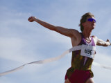 Male Runner Victorious at the Finish Line in a Track Race Lámina fotográfica