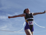 Female Runner Victorious at the Finish Line in a Track Race Photographic Print