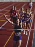 Female Runner Victorious at the Finish Line in a Track Race Photographic Print
