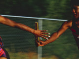 Female Runner Competing in a Relay Track Race Photographic Print