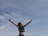 Female Runner Victorious at the Finish Line in a Track Race Photographic Print